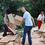 Hana, Kayode and Leticia lay out cardboard while Howard waters